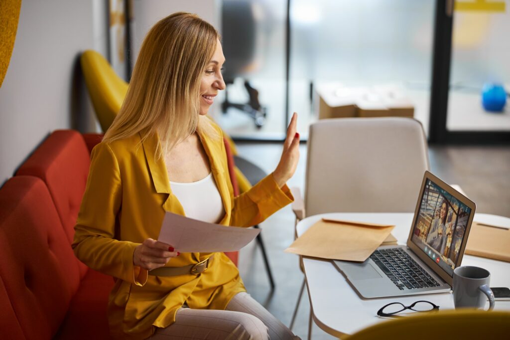 Young cheerful woman having online business meeting
