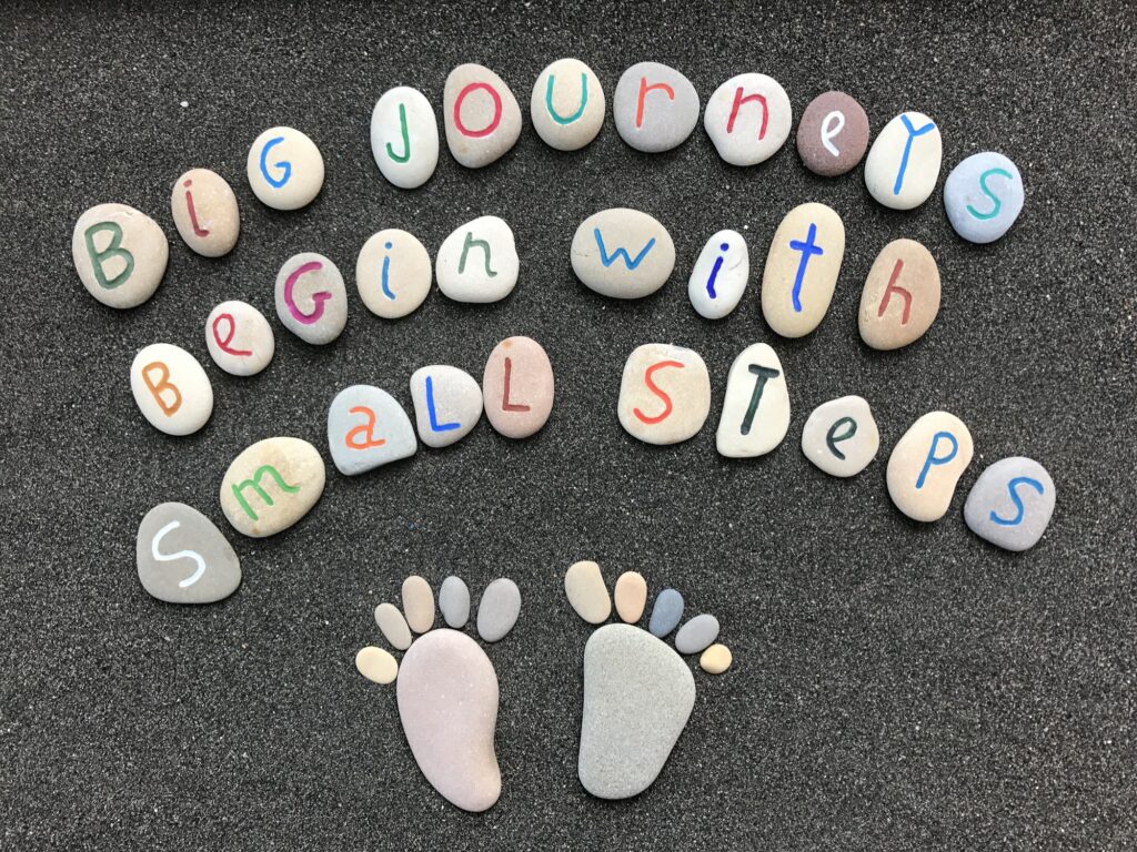 Big journeys begin with small steps, inspirational quote with stones